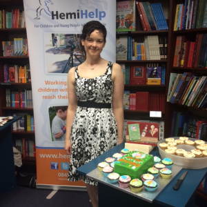 Susie at her launch party, in front of the info banner for HemiHelp, the charity for people and families affected by hemiplegia